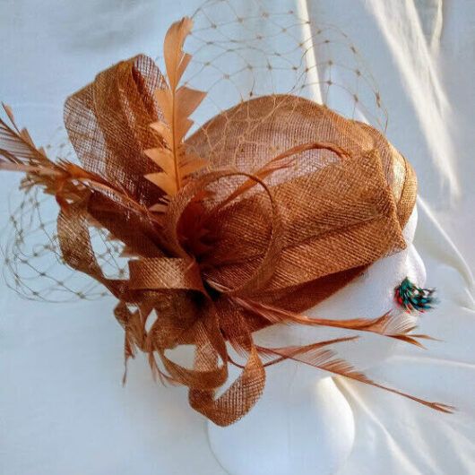 Tocado Casquete realizado en paja con adorno de lazo y plumas