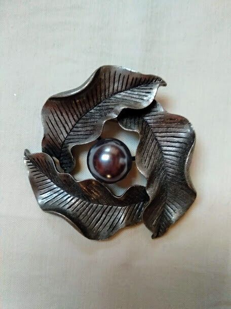 Broche bisuteria con tres hojas y perla central color plata vieja.Nuevo