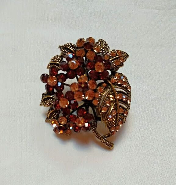 Broche bisuteria tipo vintage  con piedras tonos marrones.Nuevo