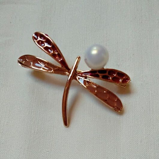Broche bisutería con forma de libelula con perla posada en el ala.Nuevo